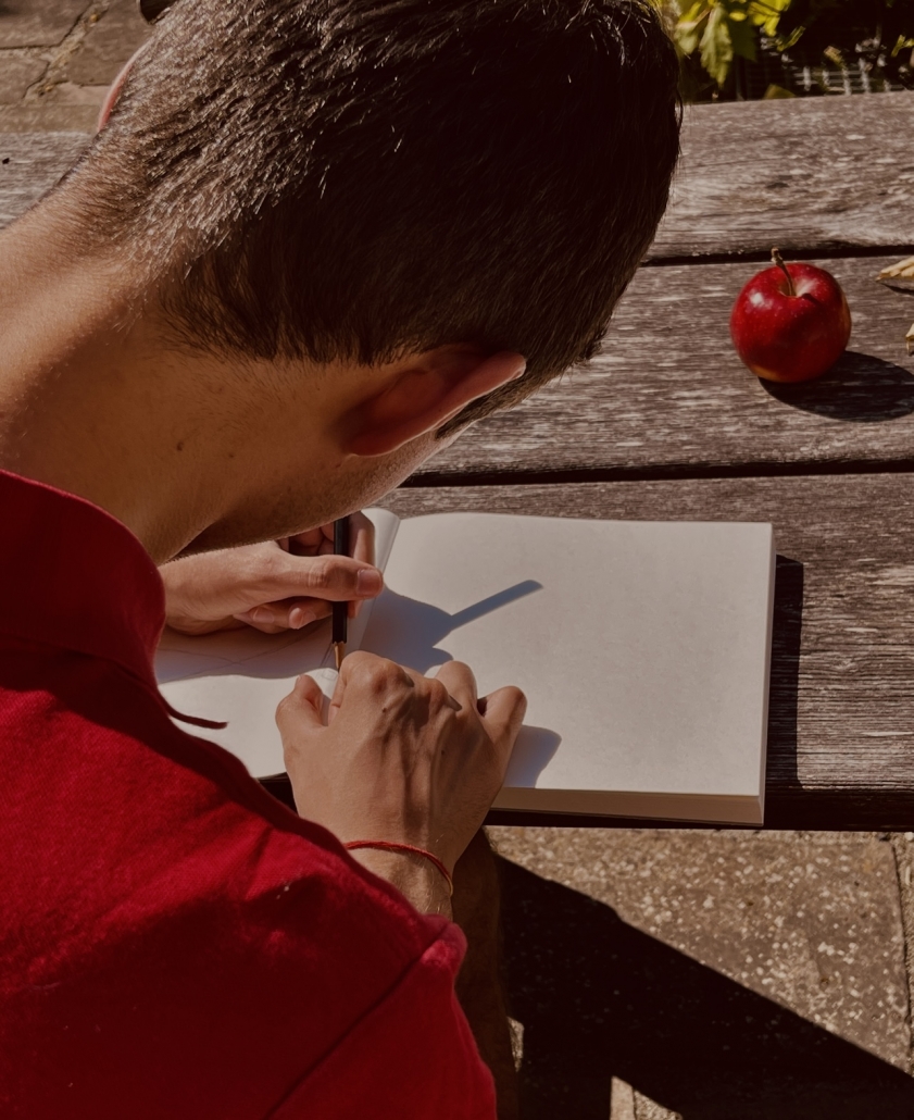 Over-the-Shoulder-Shot eines Schülers beim Malen eines Apfels - Version 2